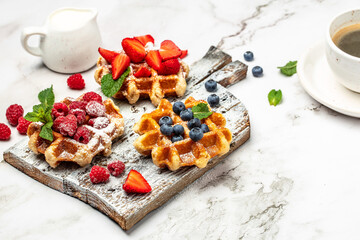 belgian waffles with fresh fruit on a light background. Long banner format. top view