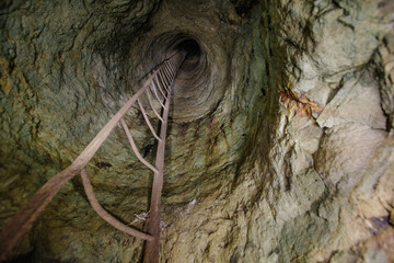 View from inside vertical stone tube downcast shaft with ladder