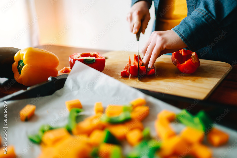 Wall mural Chef hands cutting vegetables mix for roasted vegetarian recipe - Vegan healthy food cooked on oven tray - Focus on hand holding pepper