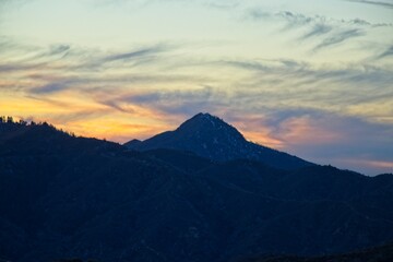 Fototapeta na wymiar The sun sets and dusk falls on the Angeles Crest Highway, a winding route through the San Gabriel Mountains and Angeles National Forest just north of Los Angeles