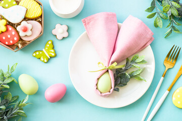 Easter food background. White plate with eggs, spring flowers and easter cookies. Flat lay.