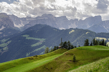 Fototapeta na wymiar Rolling green meadows above La Val village with Sass de Putia mountain, Alta Badia, Dolomites, South Tyrol, Italy