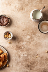 Crepes with chocolate and hazelnuts on beige background. Thin pancakes as delisious breakfast or dessert concept, Pancake day, Maslenitsa. Top view, copy space
