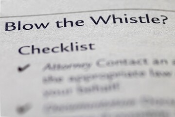 legal or law book with blow the whistle or whistleblower focused in closeup of explanation