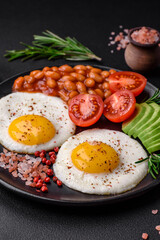 Delicious nutritious English breakfast with fried eggs, tomatoes and avocado
