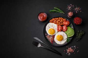 Delicious nutritious English breakfast with fried eggs, tomatoes and avocado