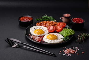 Delicious nutritious English breakfast with fried eggs, tomatoes and avocado