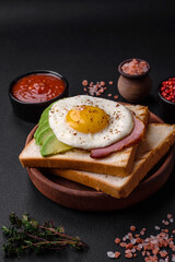 Delicious nutritious English breakfast with fried eggs, tomatoes and avocado
