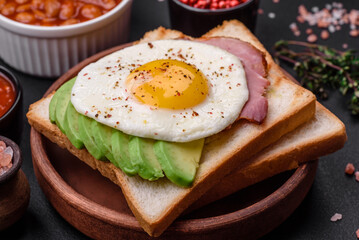 Delicious nutritious English breakfast with fried eggs, tomatoes and avocado