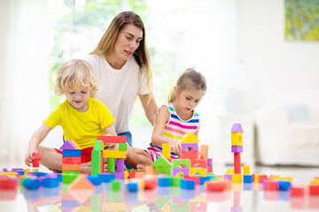 Obraz na płótnie Canvas Kids play with toy blocks. Family at home.
