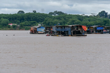 Several colorful floating riverhouse on the Amazon river in Brazil.