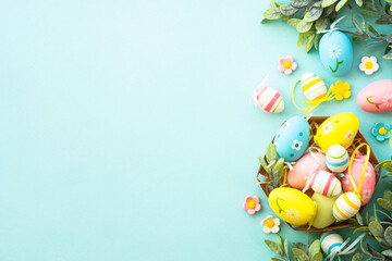 Easter eggs in the nest on blue background. Easter decor. Flat lay image with copy space.
