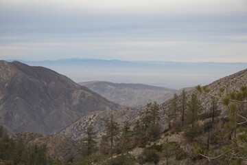 Fototapeta na wymiar The winding Angeles Crest Highway provides views over the Los Angeles Basin and surrounding urban valleys, the snow-dusted San Gabriel and San Bernandino Mountains and the Mojave Desert