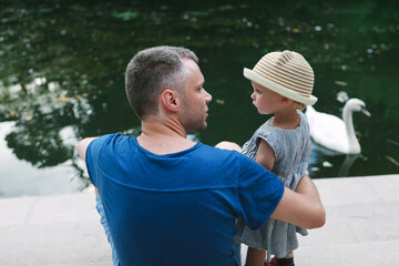 Naklejka premium dad and daughter look at each other in the park. Father's Day Concept