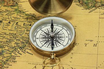Classic round compass on background of old vintage map