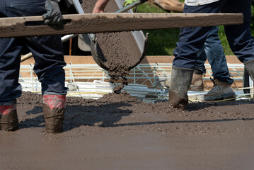 Workers pouring cement for a concrete floor