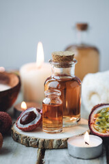 Glass bottles with pure organic essential litchi and passion fruit oil on wooden background....