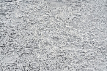 Ice on frozen river, trapped bubbles forming crystal like structures, closeup macro detail from above - abstract winter background