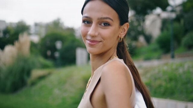 Portrait beautiful woman smiling camera at green garden. Hispanic model walking