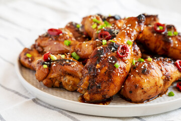 Homemade Easy Sticky Chicken Drumsticks on a Plate, side view. Close-up.