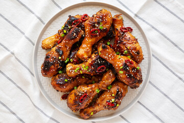 Homemade Easy Sticky Chicken Drumsticks on a Plate, top view. Overhead, from above, flat lay.