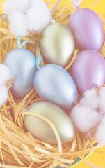 Fototapeta na wymiar colored easter eggs in a nest, easter in a basket on a festive orange background. The minimal concept of Easter. top view. Easter card with a copy space for text.Soft focus