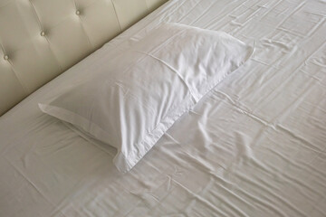 White linens and pillows, plush headboard. Royal bed in the hotel