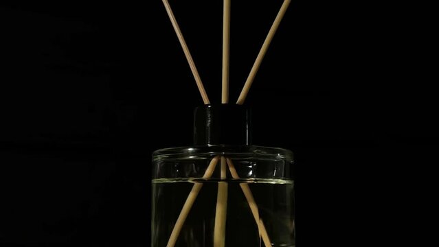 A reed diffuser rotate on a black background.  