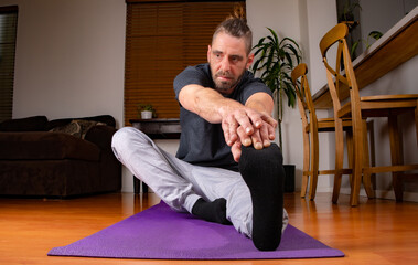 Male Stretching at home in sweats