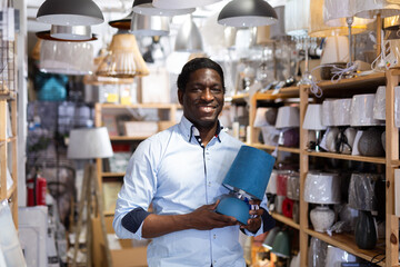 Man chooses a table lamp in an electrical store