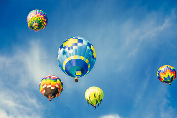 Colorful hot air balloons flying in the blue sky with white clouds