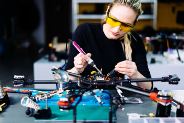 Engineer working on racing fpv drone combat kamikaze bomber in workshop.