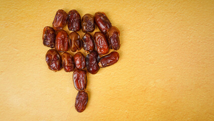 Dried dates (fruits of date palm) on yellow background. ramadan concept