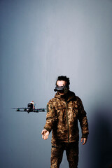 Soldier in military camouflage uniform holding fpv racing kamikaze drone bomber on blue background. Starting motors