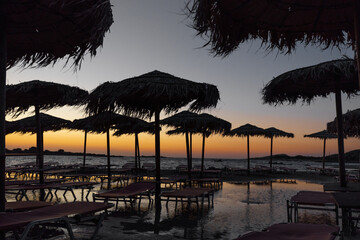 Beautiful evening scenery with sea shore, sunbeds and palm trees on the beach, Greece, Crete