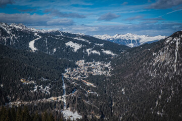 Aerial view of ski resort Madonna di Campiglio, italy. Morning is the winter season. In the background a clear blue sky. January 2023