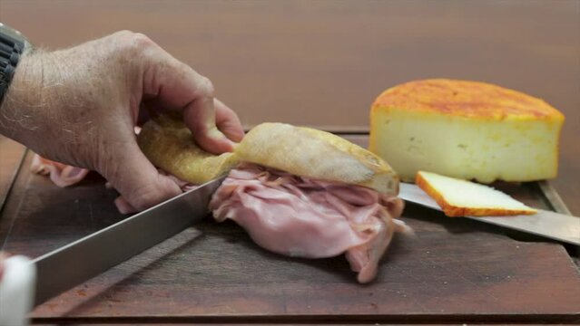 cutting a traditional mortadella sandwich