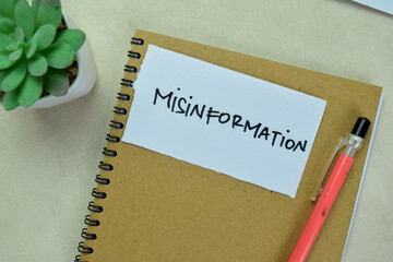 Concept of Misinformation write on sticky notes isolated on Wooden Table.