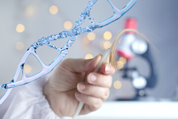 human dna structure, laboratory assistant examines hair sample, curls package for research by genetic research in laboratory, trichologist conducts test, concept DNA analysis, establishing paternity