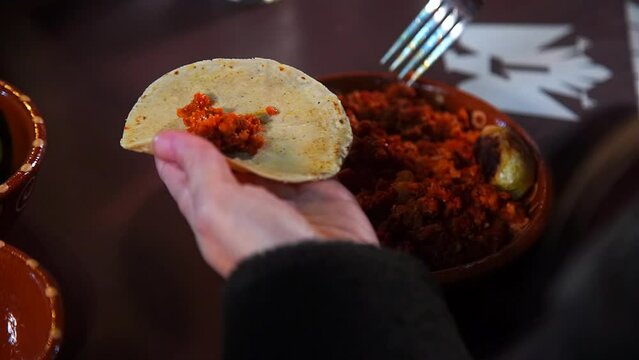 Filling a Fresh Tortilla with Spiced Meat al Pastor. Preparing an Authentic Mexican Pastor Taco.