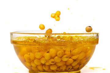 Yellow Soy Bean in Vegetable Oil pour fall down in Air. Golden Soybean mix with cooking oil pouring...