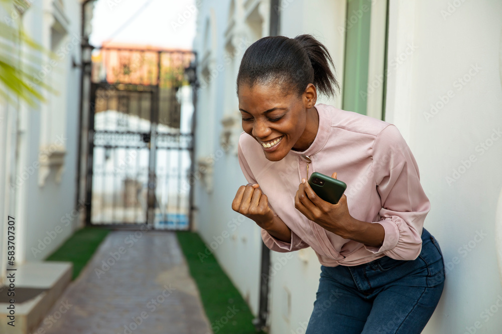 Wall mural attractive young happy black woman holding cellphone