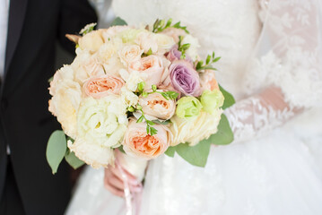 bride holding wedding bouquet with her hands	