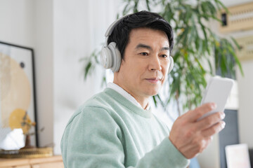 休日に自宅で音楽を聴く50代男性