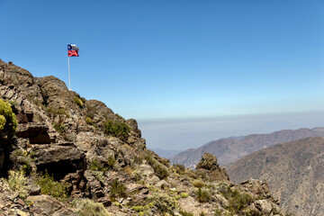 Fototapeta premium Chilean flag at Refugio Aleman in the Andes at Yerba Loca Nature Sanctuary in Chile