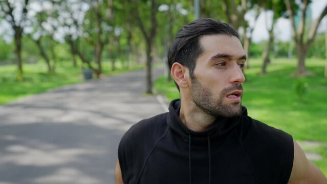 Handsome Caucasian man jogger in sportswear jogging exercise at public park in summer morning. Healthy guy athlete enjoy outdoor activity lifestyle sport training fitness running workout in the city.