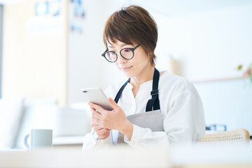 メガネをかけてスマートフォンを操作する女性