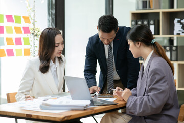 Group of asia business people sitting and talking, meeting, presenting, presenting graphs, chatting happily at the office.