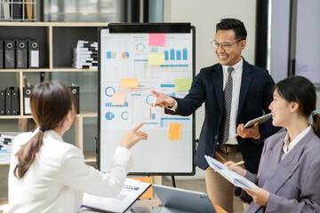 Group of asia business people sitting and talking, meeting, presenting, presenting graphs, chatting happily at the office.
