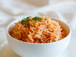 Tomato onion rice, Tamatar Biryani, jollof in white bowl on a white wooden table, horizontal, close up